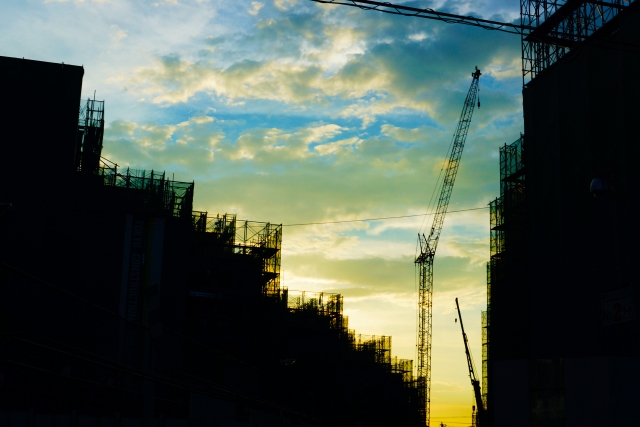 建設途中のビルと日暮れ前の青空